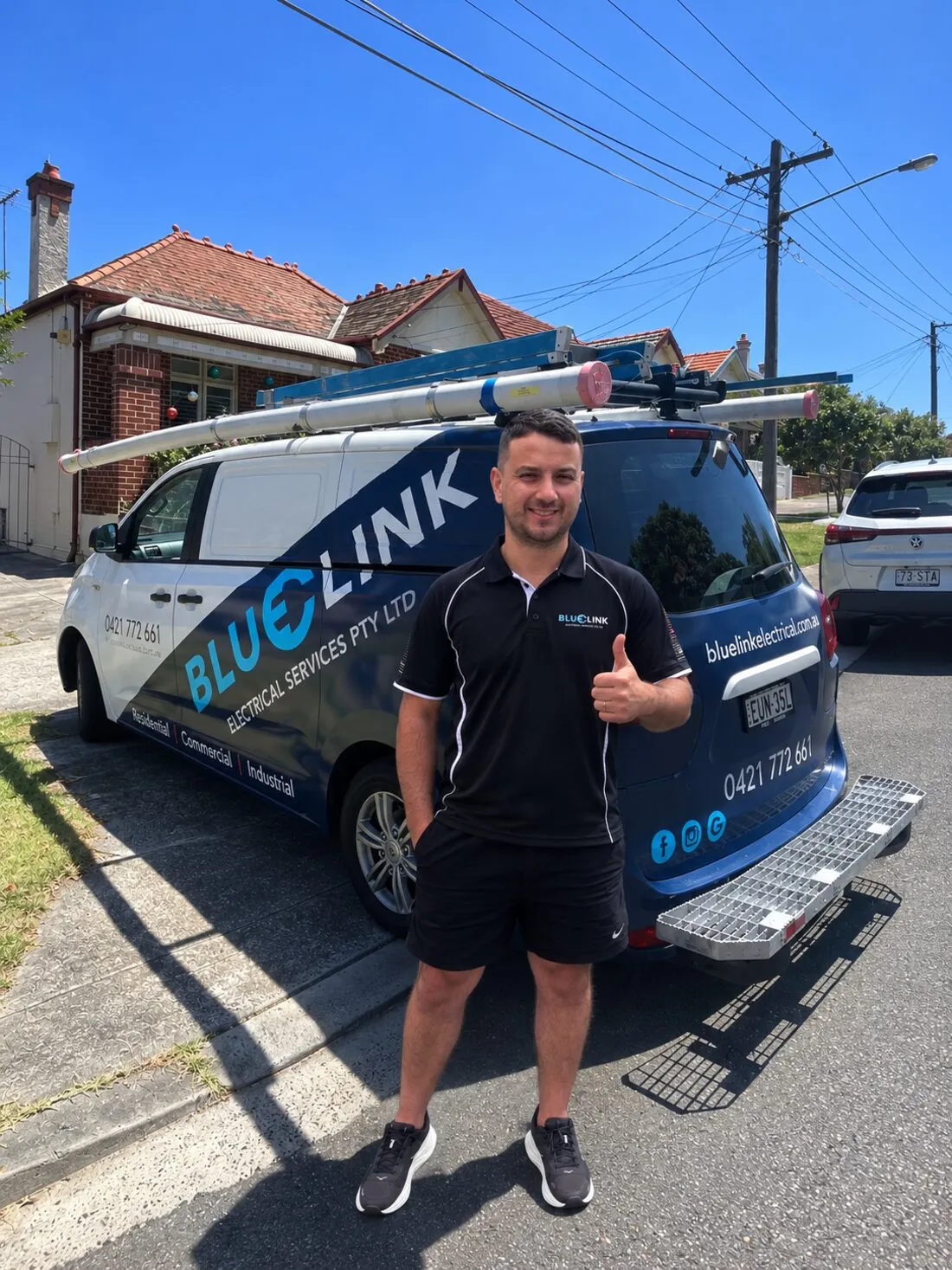 Blue Link Electrical Services electrician in front of the branded work van