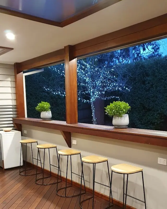 Alfresco bar with stools and downlights in the ceiling at night