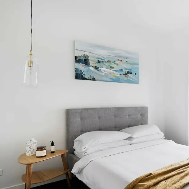 Glass pendant light hanging beside a bed