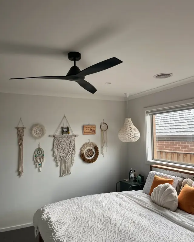 Black three-blade ceiling fan installed in a bedroom