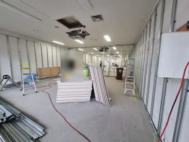 Commercial fit-out in progress with steel stud walls, cabling and ceiling openings