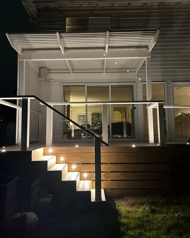 Timber deck stairs with small step lights lit at night