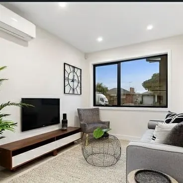 Living room with recessed downlights and a split system air conditioner