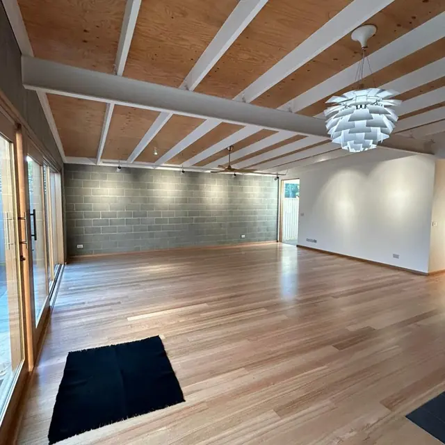 Large white feature pendant hanging from a raked timber ceiling