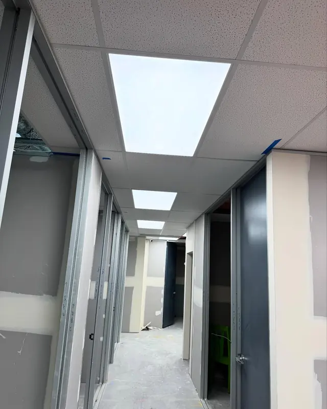 Office corridor with recessed LED panel lights in a suspended ceiling