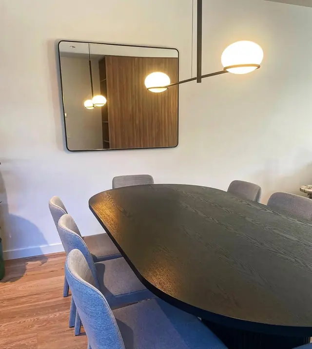 Globe pendant light above a long dark dining table