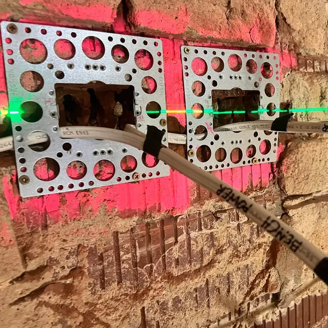 Wall box mounting brackets and new cable on a brick wall during rough-in