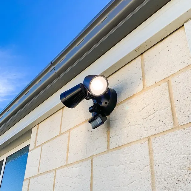 Twin-head sensor security light mounted under an eave