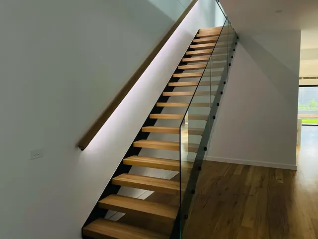 LED strip lighting in a recessed handrail beside open timber stairs