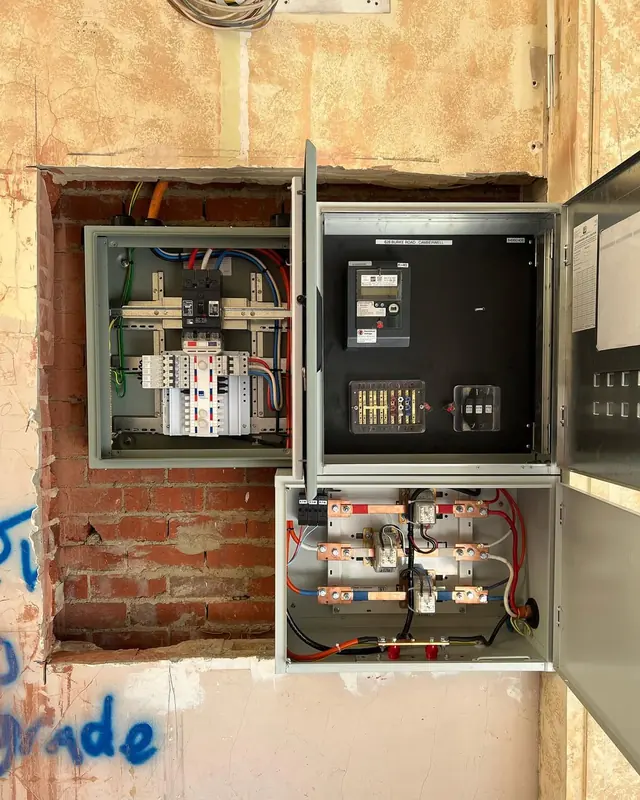 Switchboard upgrade in progress with new enclosures in a brick wall recess