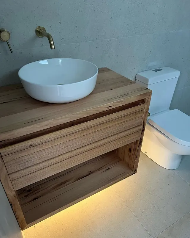 LED strip light glowing under a timber bathroom vanity